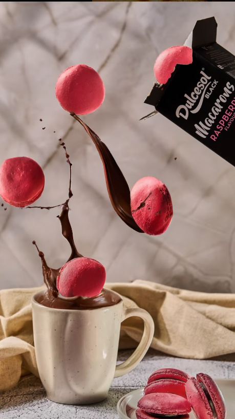 Fotografía gastronómica de repostería en Valencia – macarons flotando con chocolate y luz narrativa.