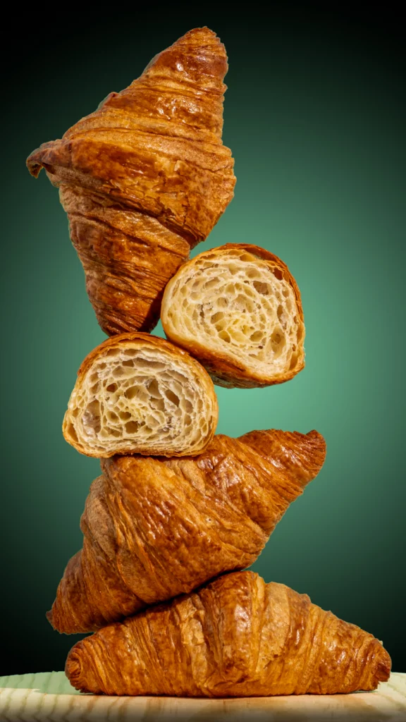 Croissants apilados con relleno visible fotografía comercial para repostería foodbyleo