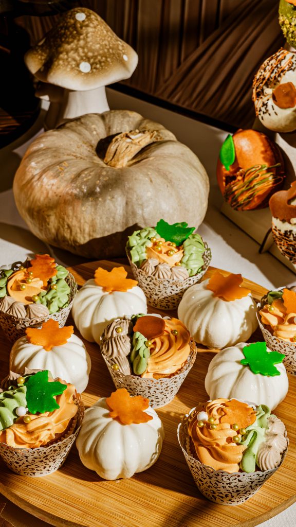 cupcakes glaseados sobre tabla en mesa otoñal