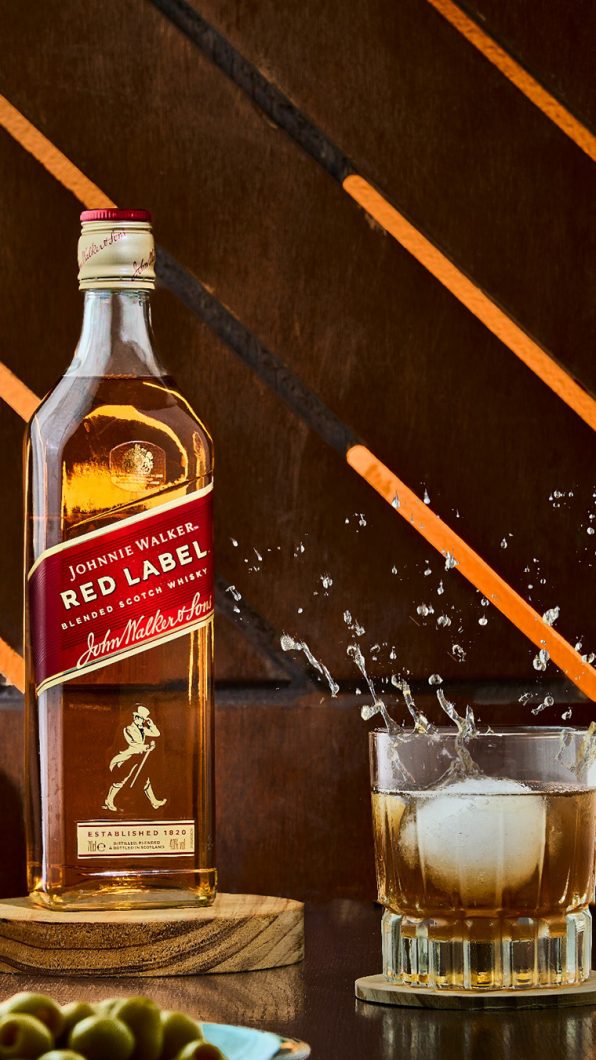 botella de wisky con vaso y splash fotografia para marcas gastronomicas en valencia foodbyleo